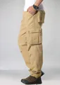 Pantalón cargo caqui para hombre de corte relajado con múltiples bolsillos, vista lateral. - 29 / Bottoms / Caqui