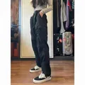 Full length side view of women's black waterproof techwear cargo pants in room. - S / Bottoms / Summer Lightweight / Black