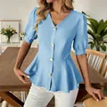 Close-up detail of a light blue V-neck puff sleeve peplum blouse with gold buttons. - Sky Blue
