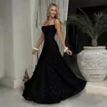 Elegant black spaghetti strap evening gown with floral texture and long flared skirt. - Black