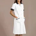 Detailed view of a professional white nursing uniform dress with black contrast lapel and pockets - S / Top And Bottom / White