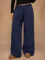 Detalle de pantalón de chándal de forro polar azul marino con pernera ancha y cordón. - Azul marino