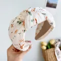 Nahaufnahme eines eleganten Haarreifs mit vintage floralem Print in sanfter Creme Farbe - Knoten Stirnband / Beige Tierdruck