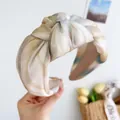 Nahaufnahme eines marmorierten Haarreifens mit Knoten in eleganten sandigen Naturtönen. - Knoten Stirnband / Grüner Fleck