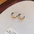Gros plan détaillé de boucles d'oreilles créoles torsadées dorées en forme de C - 4# Aiguille d'argent