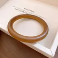 Detailansicht eines vintage braunen runden Armreifs mit glatter, holzähnlicher Harztextur - Bernstein Harz Armreif / Bernstein