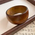 Detaillierte Makroansicht eines breiten Holzarmreifs im Vintage-Stil mit brauner Textur - Verbreiterter Holz Minimalistischer Ring / Hellbraun