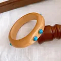 Detaillierte Ansicht eines Vintage-Holzarmreifs mit blauen Steineinlagen im Boho-Stil - Böhmischer Abgerundeter Dicker Ring / Helles Holz-Blauer Türkisimitat