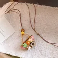Close-up of a pastoral woven flower basket pendant with colorful floral details and leather cord - Multicolor Woven Flower Basket / Necklace-Coffee-Multicolor-Basket