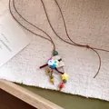 Close-up of handmade flower basket pendant necklace with leather cord and star bead - Multicolor Decorative Flower Basket / Necklace-Brown-Multicolor