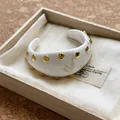 Elegante brazalete de resina marmoleada blanca con remaches dorados en caja de madera - Pulsera #8 - Dorado y blanco