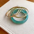 Macro detail of turquoise resin bangle and gold-tone metal bracelet set of five - Five-Piece Set / Gold-Green
