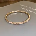Elegante gouden armband met twee rijen schitterende strassteentjes in close-up - Goud (Roze)
