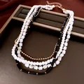 Gros plan d'un collier élégant à plusieurs rangs avec perles et perles noires - Or-Blanc-Noir