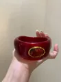 Detailed close-up view of a chunky retro red acrylic bangle with gold-tone frame - Metal Frame Red Oval Bangle / Gold-Red