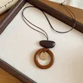 Gros plan détaillé d'un collier ethnique avec pendentif géométrique en cuir résine et bois - Style Anneau en Bois avec Motif Chrysanthème (35#)
