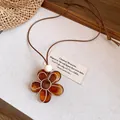 Vue détaillée d'un pendentif fleur en résine ambre avec cordon en cuir et perle en bois. - Style en forme de fleur (41#)