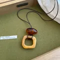 Vue détaillée d'un pendentif géométrique irrégulier en résine sur un long collier en cuir. - Style Anneau Carré Irrégulier (6#)