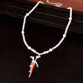 Detailaufnahme einer eleganten Perlenkette mit einem zirkonia-besetzten Karottenanhänger - Halskette / Silber-Weiß-Orange