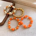 Vista detallada del conjunto de pulseras elásticas geométricas en acrílico y oro - Pulsera - Dorado / Naranja
