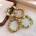 Primer plano de un conjunto de pulseras elásticas de cuentas verdes y doradas - Pulsera - Dorado / Verde