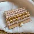 Detail of pink and gold beaded bracelet set with pearl charm on linen background - 6-Piece / Gold-Pink