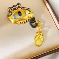 Close-up of a vintage gold eye-shaped brooch with irregular geometric hollow details - Liquid Melting Eye Pendant Style (Gold-Black)