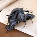 Detail of a chic black and white striped fabric bow hair claw clip with ribbons - Striped Pleated Bow Tassel Claw / Black