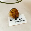 Detailed view of a trendy amber tortoiseshell resin ring placed on a woven brand label - 42# Tortoiseshell Pattern