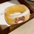 Vue macro d'un jonc géométrique en résine orné d'une grande pierre précieuse pêche - Style Géométrique Ouvert (1#) / Café Clair