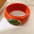 Detail of red resin bangle bracelet with green cabochon in gold frame - Geometric Open Style (33#)