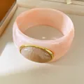 Close-up detail of a thick pink resin bangle with an oval marble-patterned stone inlay. - Geometric Open Style (36#)