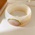 Macro view of creamy resin bangle with marble texture and elegant golden oval bezel inlay - Geometric Open Style (38#)