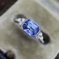 Macro detail of an emerald-cut blue zircon ring with milgrain bezel and side stones - Size 5 / Blue Rectangular Style (CY1038)