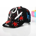 Detailed view of a black baseball cap featuring cartoon graffiti and white JOY lettering - Kids / Black
