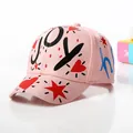 Close-up of pink graffiti baseball cap with heart and star patterns and JOY text - Kids / Pink