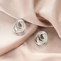 Elegant irregular silver-tone stainless steel stud earrings displayed on silk background - Double Spiral Hollow Style (E1342-B) / 1 Pair Pack / Steel