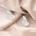 Elegant silver irregular shell stud earrings displayed on champagne satin fabric - Silver Double Fan Style (E1346-B) / 1 Pair Pack / Steel