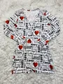 Detailed view of red heart and 'Love' typography print on a cozy white romper - S / Top And Bottom / Black White Letter