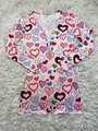 Detailed view of pink long sleeve romper with colorful heart prints on white shaggy rug - S / Top And Bottom / Pink Heart