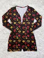 Close-up of the vibrant heart and lip pattern on a black long sleeve pajama romper - S / Top And Bottom / Lipstick Printed