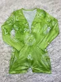 Detail showing green Leo zodiac print and metal buttons on the long-sleeve romper - Leo