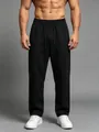 Detail view of men's loose black quick-dry sports pants with straight-leg cut on model - S / Bottoms / Black