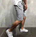 Detailansicht grauer Herren-Sportshorts mit lässigem Saum und praktischer Seitentasche. - Hellgrau