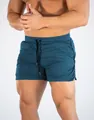 Close-up view of teal quick-dry mesh running shorts for men on muscular fitness model - M / Bottoms / Dark Blue
