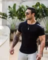 Close-up of muscle-fit black compression t-shirt showing the sleeve print detail. - M / Tops / Black Shoulder Print