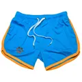 Detail of blue mesh athletic shorts featuring orange trim and a paw print logo design - M / Tops / Sky Blue Yellow Edge