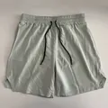 Nahaufnahme von leichten schnell trocknenden Herren-Sportshorts mit Kordelzug. - Hellgrün
