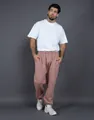 Detail view of mauve fleece-lined joggers paired with white sneakers on a model - Pink