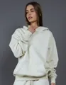 Detailed view of a premium cream oversized heavyweight fleece hoodie on a female model - S / White